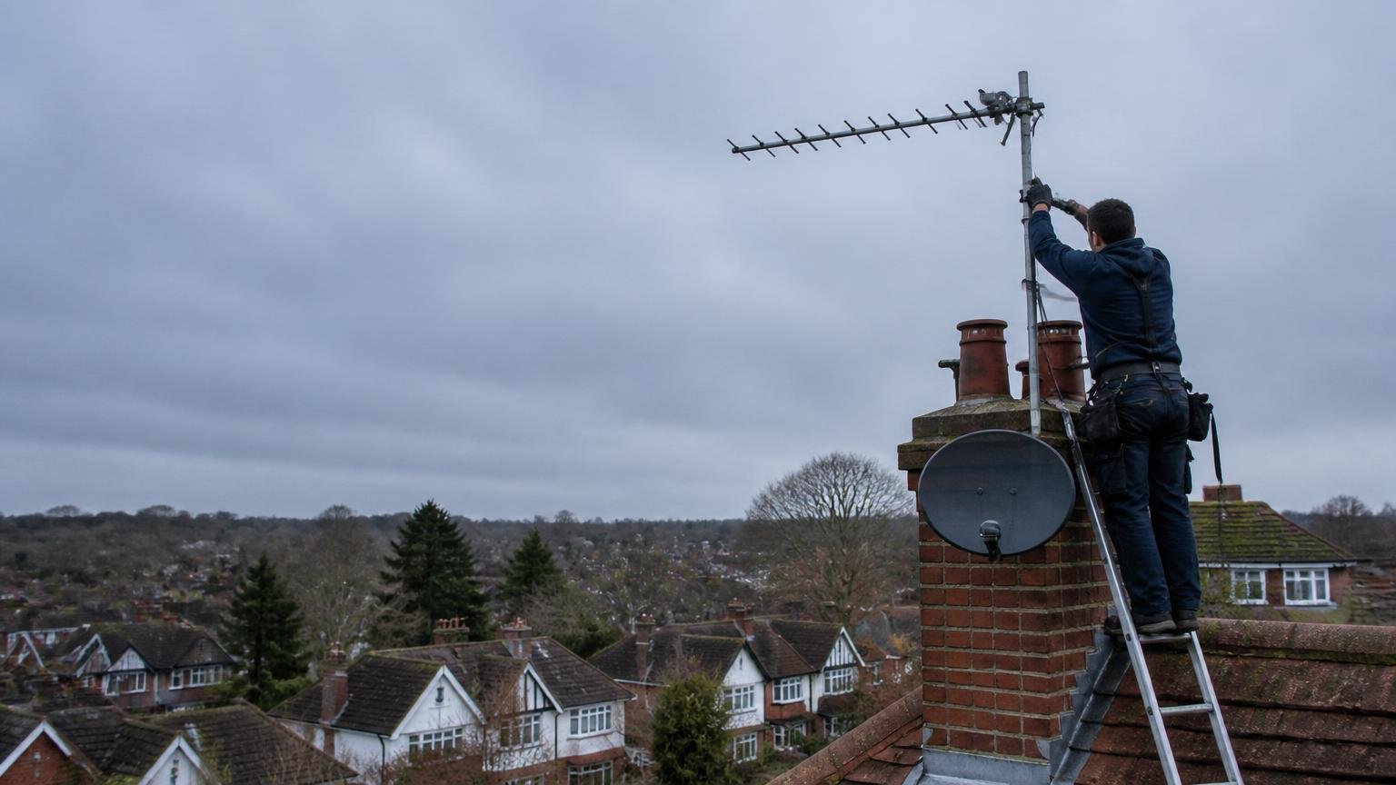 Two Epsom Aerials engineers in front of their work van on a Surrey street